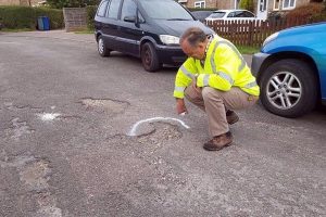 Graham inspecting a pothole